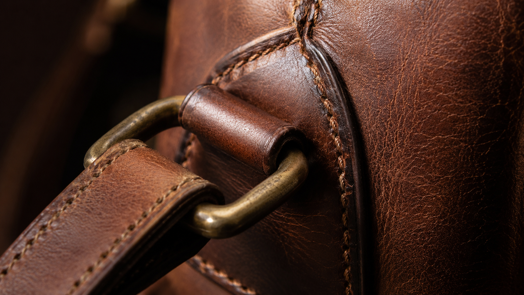 Close-up of brass hardware and double stitching to inspect when choosing a leather backpack